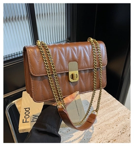 Detail of vintage brown quilted bag with old gold chain strap and metal turn-lock closure