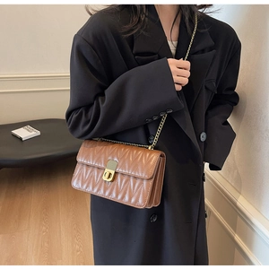 Close-up of the vintage brown quilted crossbody bag with a golden metal twist lock and chain