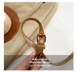 Détail de la bandoulière réglable en cuir marron avec boucle en métal doré chic