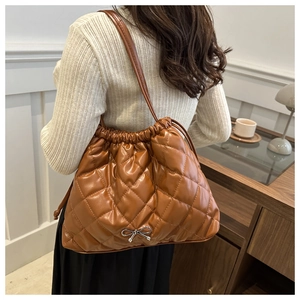 Quilted brown faux leather tote bag with drawstring closure and silver bow detail