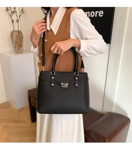 Detail der schwarzen Leder-Shopper mit silbernem Drehverschluss und Schulterriemen