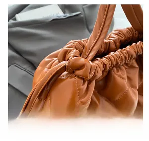 Detail of the brown quilted bucket bag showing pleated drawstring closure and texture
