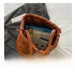 Spacious interior of brown quilted tote bag showing tablet and daily essentials