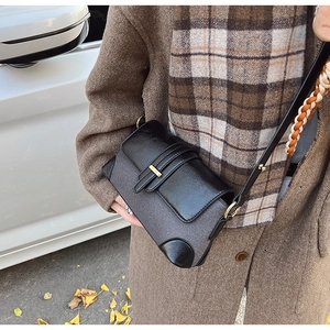 Detail of French vintage shoulder bag with black leather patchwork and gold buckle