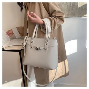 Details der cremeweißen Handtasche aus Leder mit Narbenstruktur und Metalldrehverschluss