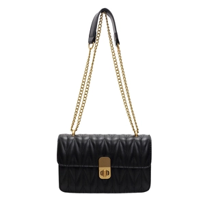 Quilted black leather crossbody bag with gold chain strap and metallic twist lock