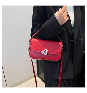 Detail of red leather underarm bag with signature heart-shaped silver metal buckle