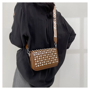 Detail of brown PU leather crossbody bag with silver studs and geometric strap