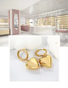 Détail macro de boucle d'oreille cœur en or 18K avec finition métallique polie miroir