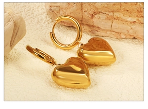 Détail de boucles d'oreilles créoles cœur dorées avec finition poli miroir