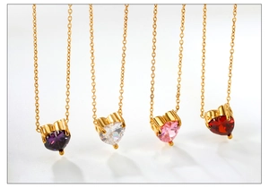 Dettaglio di ciondoli in zircone a forma di cuore viola, rosa, bianco e rosso su catene d'oro