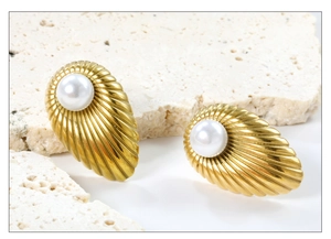 Close-up of vintage gold floral earrings with pearls on a travertine stone background