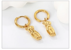 Artistic golden female torso drop earrings with polished finish and elegant ring link