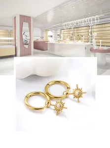 Detail of gold starburst hoop earrings with center pearl bead for a vintage look