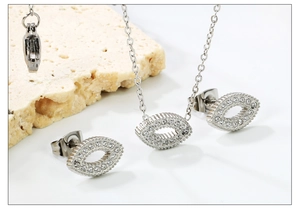 Macro view of silver hollow oval necklace and earrings set with pavé stones on stone base