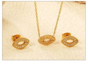 Close-up of golden eye-shaped jewelry set with white zircons and radial texture