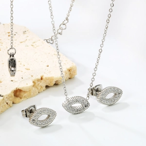 Silver evil eye jewelry set with sparkling zircon stones on an elegant travertine base