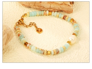 Macro shot of bohemian beaded bracelet featuring natural stones and white pearl detail