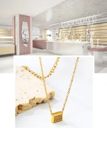 Macro detail of gold geometric pendant with shimmering pavé crystal settings on fine chain