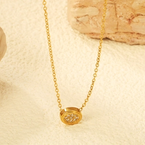 Minimalist gold coin necklace featuring round sparkling zircon paving on rock background