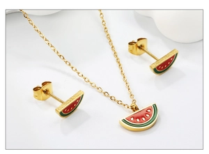 Macro detail of watermelon enamel jewelry set with golden chain and stud earrings