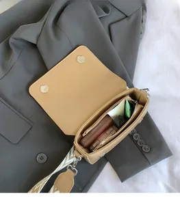Detail of small square bag interior showing spacious main compartment and magnetic snaps