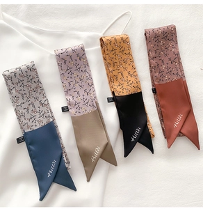 Detail of floral and solid silk scarves styled on white fabric for elegant accessories