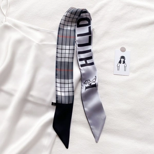 Détail d'un foulard étroit à carreaux avec imprimé HILLDI et motif de chiot sur soie blanche