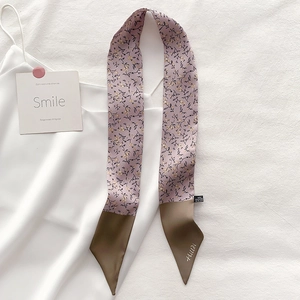 Detail of floral narrow scarf made of 100% polyester with vintage flower print and logo