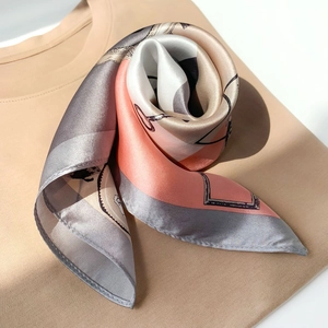Close-up of printed silk square scarf showing detailed stitching and premium satin texture