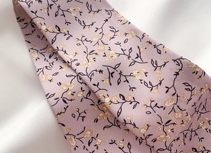 Close-up of floral print twill fabric scarf with delicate yellow flowers on purple background