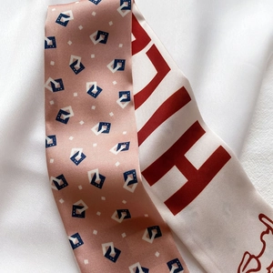 Détail de la texture d'un foulard en soie avec imprimé géométrique rose et alphabet