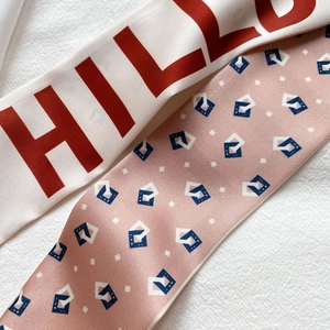 Détail de foulards fins en satin avec imprimé lettres et motifs géométriques