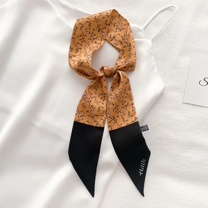 Detailed macro view of floral print silk scarf with 100% polyester fabric care label