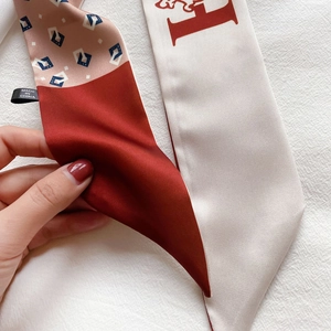 Vue détaillée d'un foulard en soie avec motif H et contraste de couleur orange vif