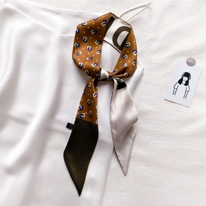Twilly en soie à carreaux caramel et vert olive avec motifs géométriques sur une robe satinée