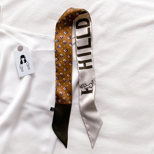 Détail d'un foulard en soie à carreaux avec illustration de chien et imprimé HILLD