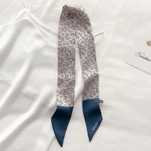 Detailed view of floral skinny scarf twilly with elegant blue satin ends and logo