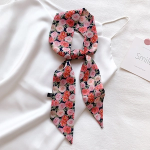 Detail of floral skinny scarf tied on silk dress featuring dark blue rose patterns