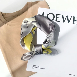 Detail of silk square scarf featuring vintage keys and portraits with satin finish