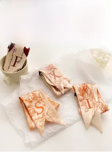 Gros plan de foulards en soie à imprimé floral avec les lettres alphabet F X S I