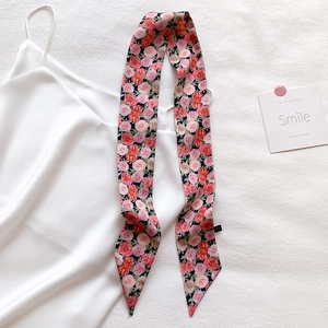 Detailed macro view of a long satin floral twilly scarf with pink rose patterns
