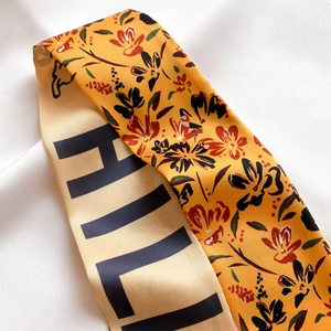Détail d'un foulard en soie double face avec motifs floraux et imprimé sur satin blanc
