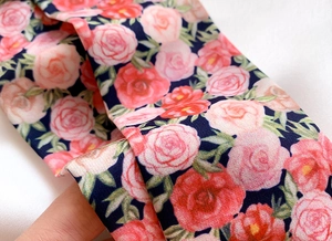 Detail shot of navy floral skinny scarf with pink rose patterns and soft twill texture