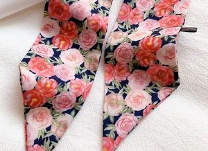 Detail of floral polyester twilly scarf with rose print and premium stitched edges