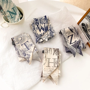 Détail de foulards twilly en soie 100% avec imprimés alphabet et étiquette d'entretien