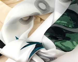 Detailansicht eines eleganten Seidentuchs mit Kettenprint und glänzendem Satingewebe