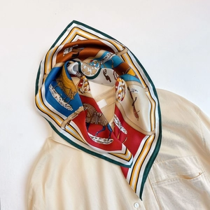 Dettaglio di un foulard di seta con stampa equestre vintage su camicia beige
