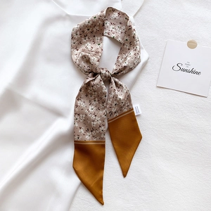 Detail of floral and yellow satin twilly scarf with elegant texture and smooth finish