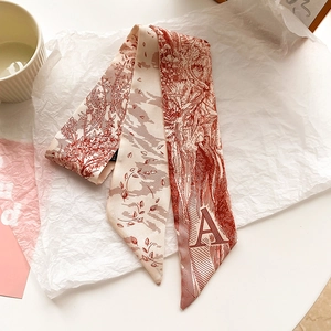 Détail d'un élégant foulard twilly en soie crème avec imprimé floral et lettre A